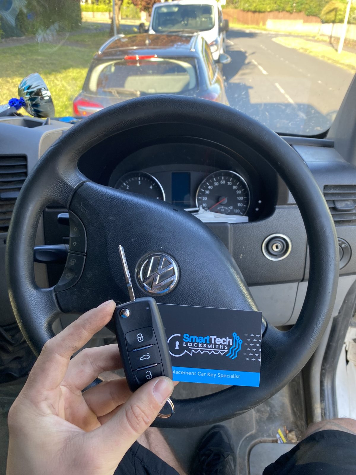 Volkswagen Crafter van flip key in Hampshire by SmartTech Auto Locksmiths, key and business card held in front of the vehicle