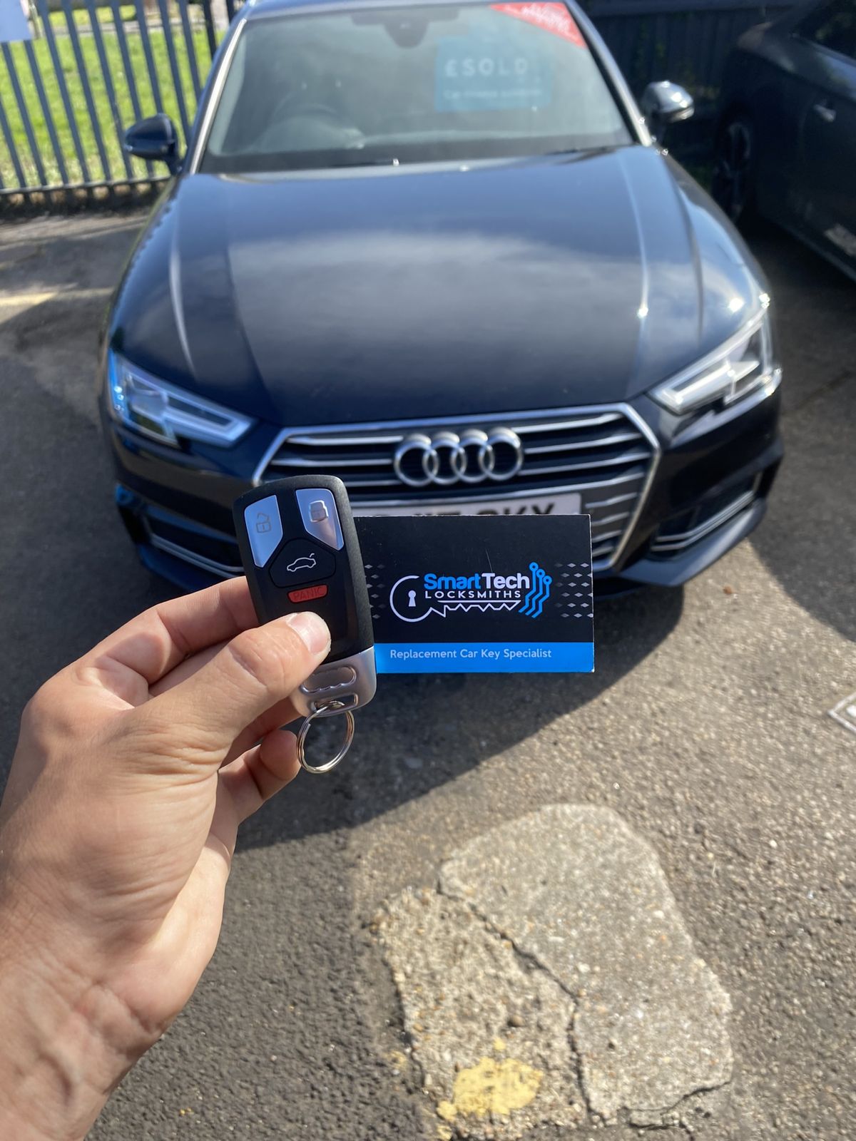 Audi A4 replacement remote key in Lymington by SmartTech Auto Locksmiths, key and business card held in front of the vehicle