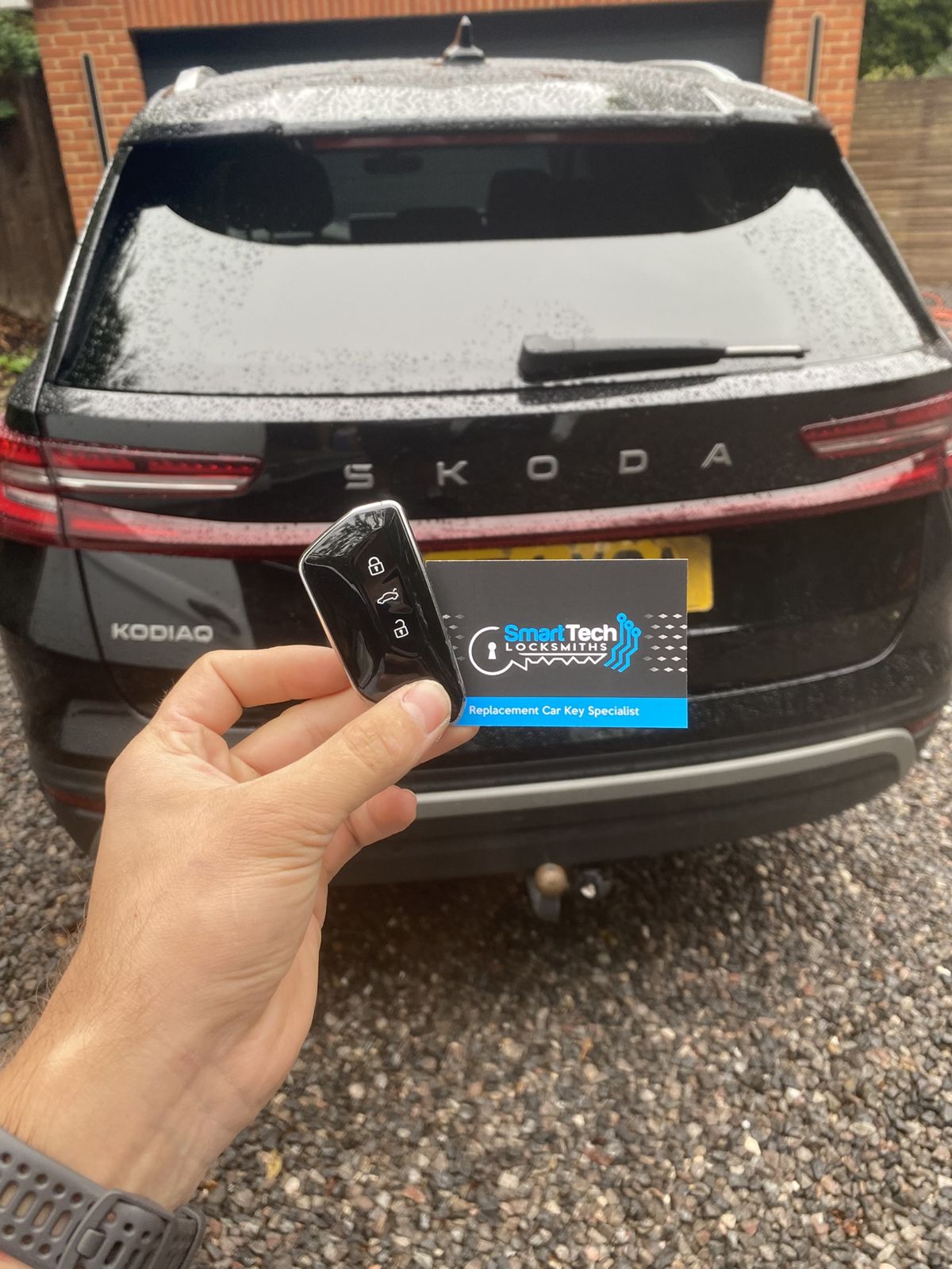 Skoda Kodiaq smart key programmed in Havant by SmartTech Auto Locksmiths, key and business card held in front of the vehicle