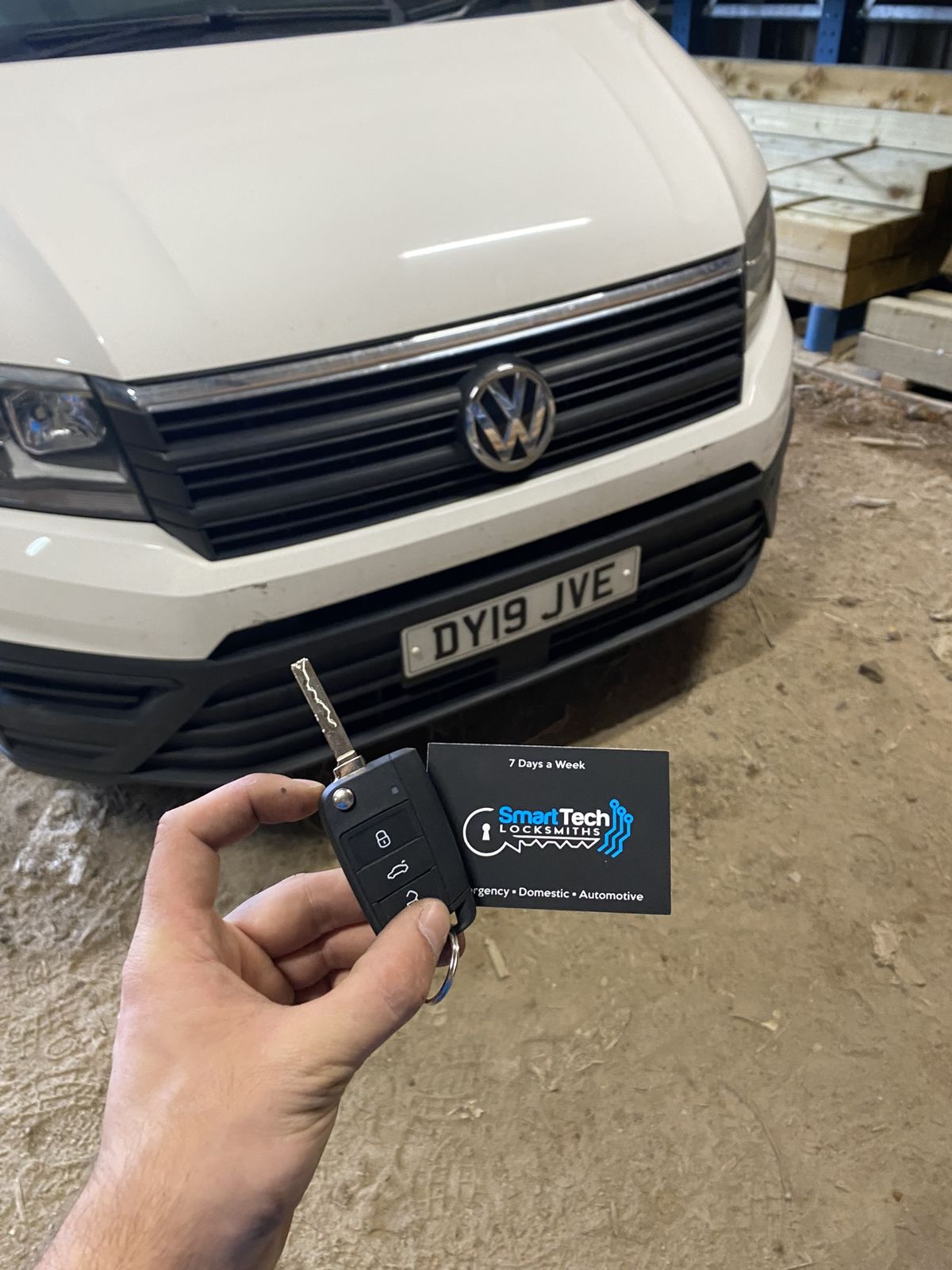Volkswagen Crafter van key cut and programmed in Southampton by SmartTech Auto Locksmiths, key and business card held in front of the vehicle