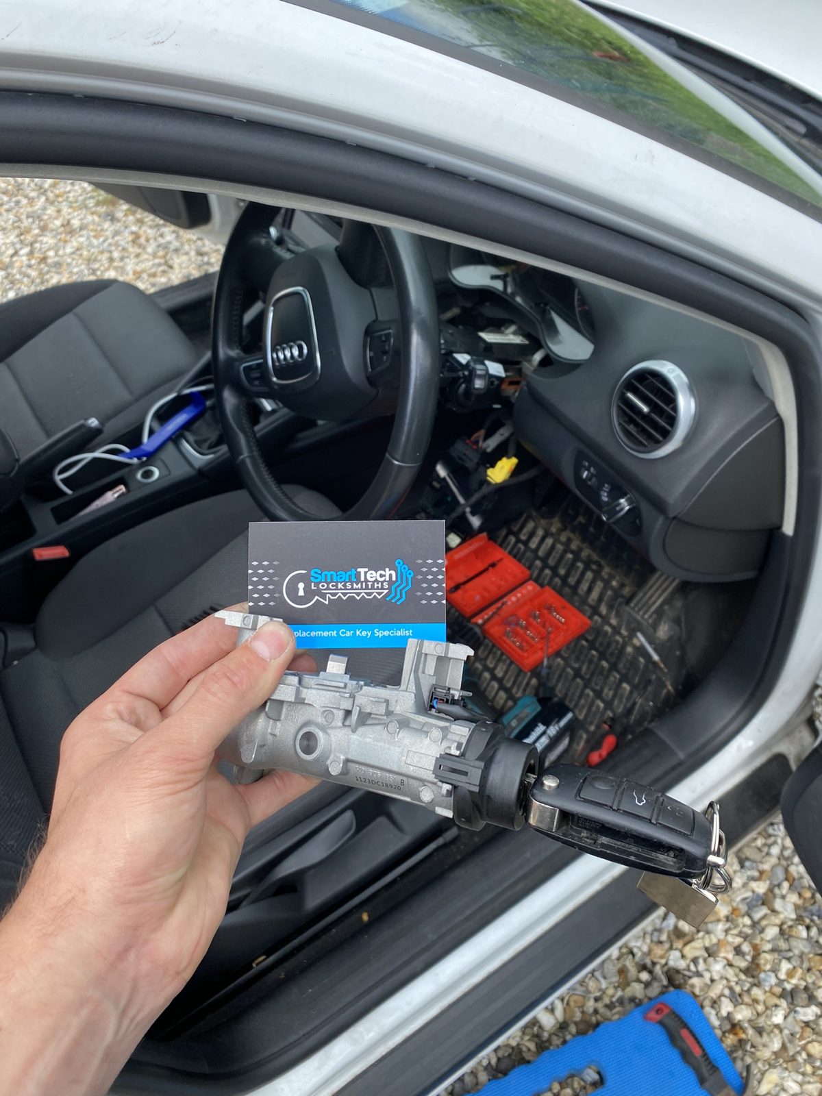 Audi A3 ignition lock replaced in Hampshire by SmartTech Auto Locksmiths, key and business card held in front of the vehicle