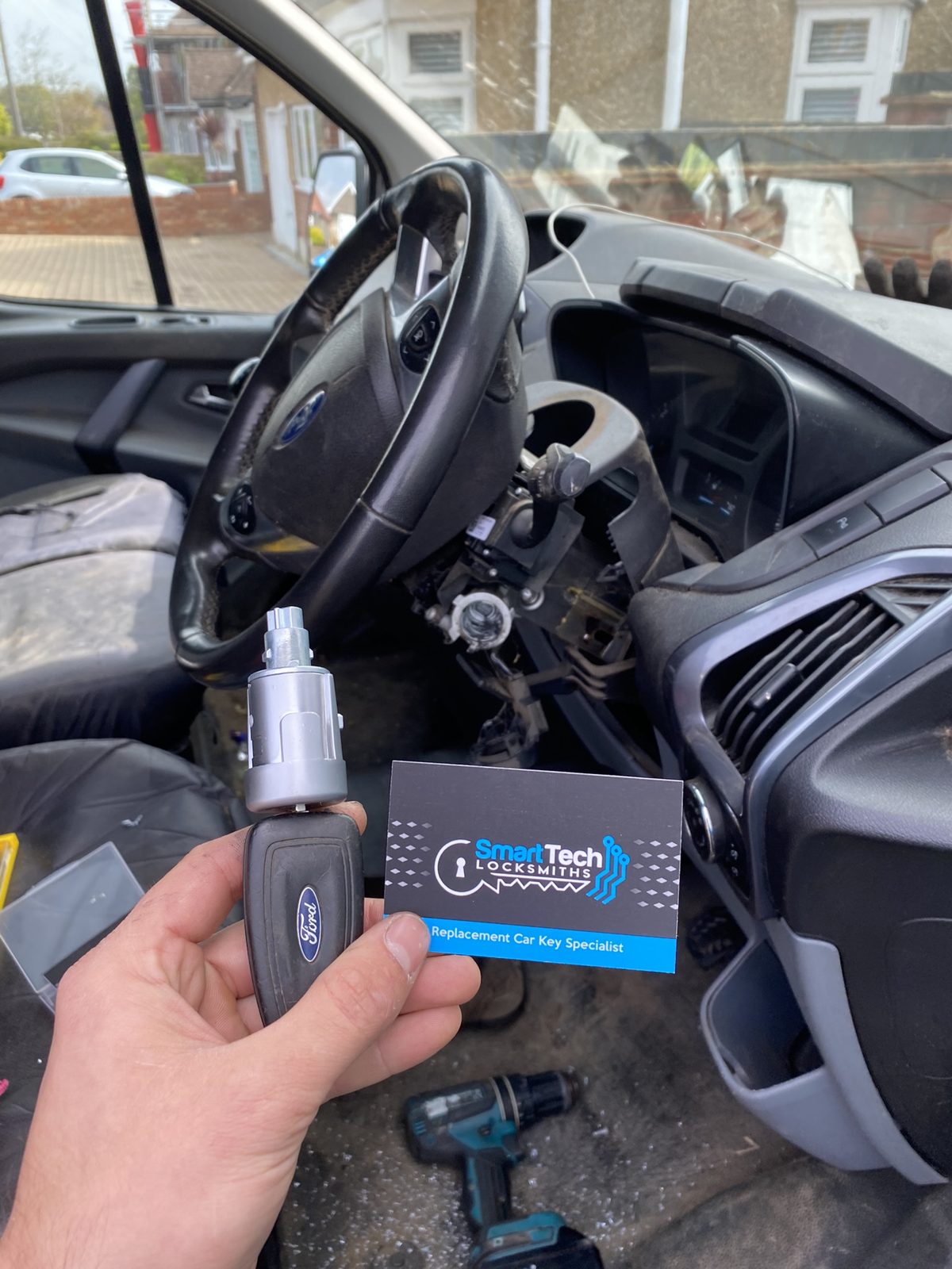Ford Transit Custom ignition lock replaced in Hampshire by SmartTech Auto Locksmiths, key and business card held in front of the vehicle
