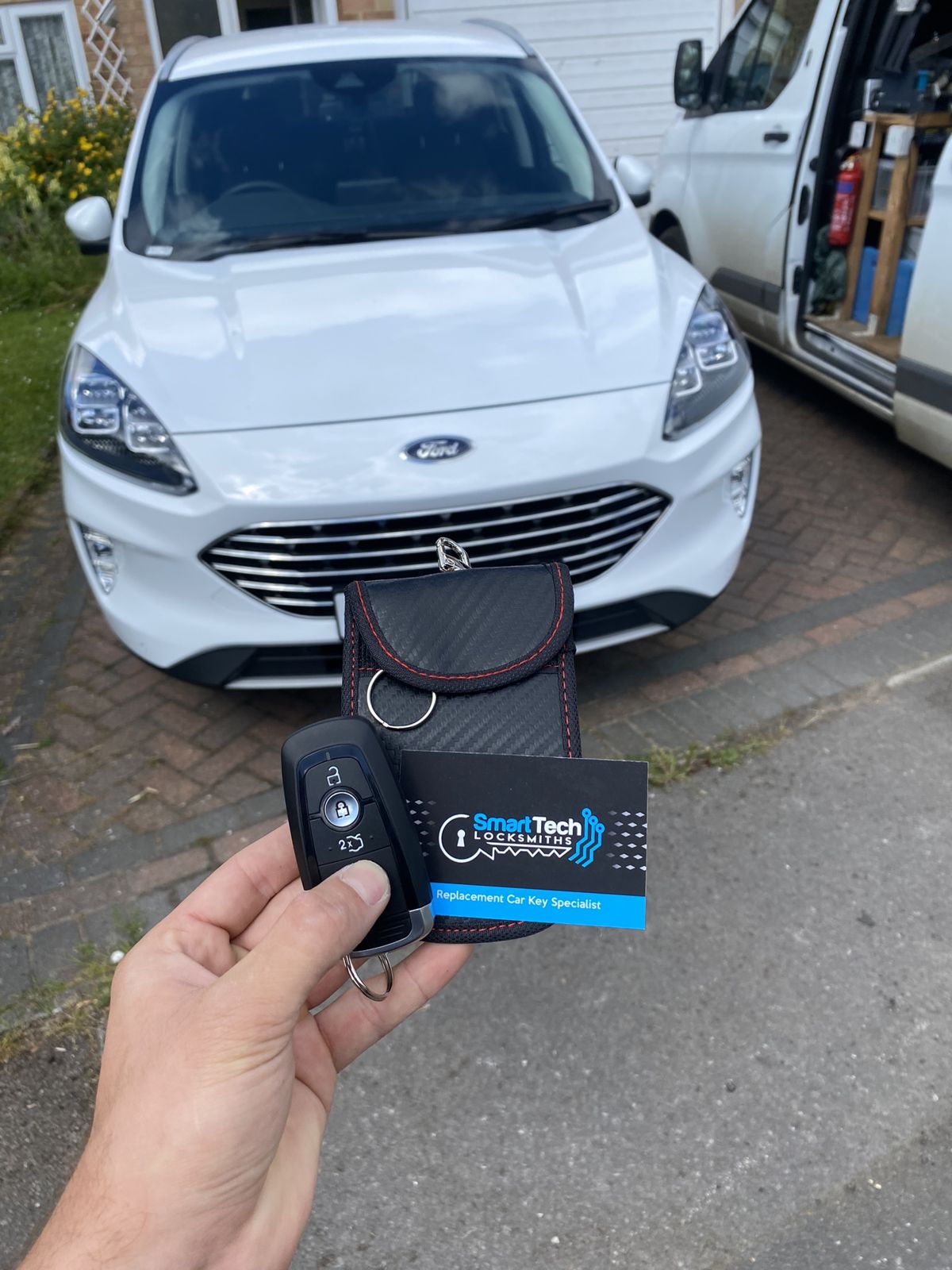 Ford Kuga replacement remote key in Hedge End by SmartTech Auto Locksmiths, key and business card held in front of the vehicle