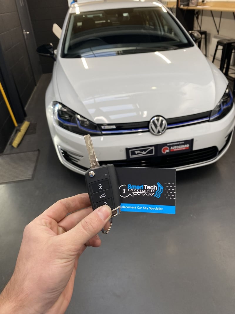 Volkswagen Golf GTE spare remote key in Shirley by SmartTech Auto Locksmiths, key and business card held in front of the vehicle