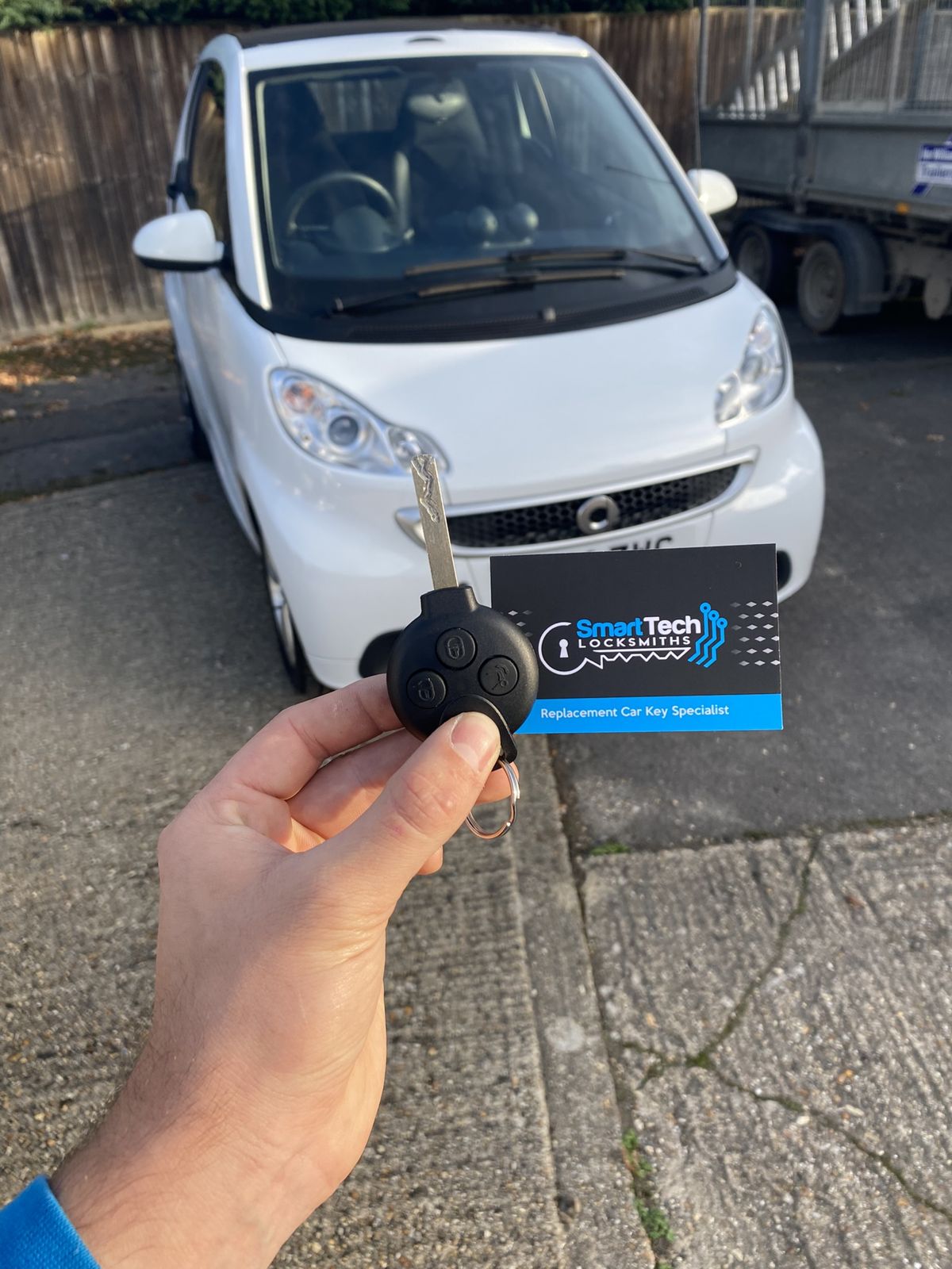 Smart ForTwo replacement key in Fareham by SmartTech Auto Locksmiths, key and business card held in front of the vehicle