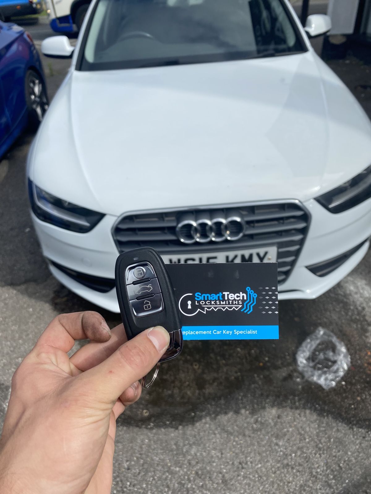Audi A4 replacement remote key in Bishop's Waltham by SmartTech Auto Locksmiths, key and business card held in front of the vehicle