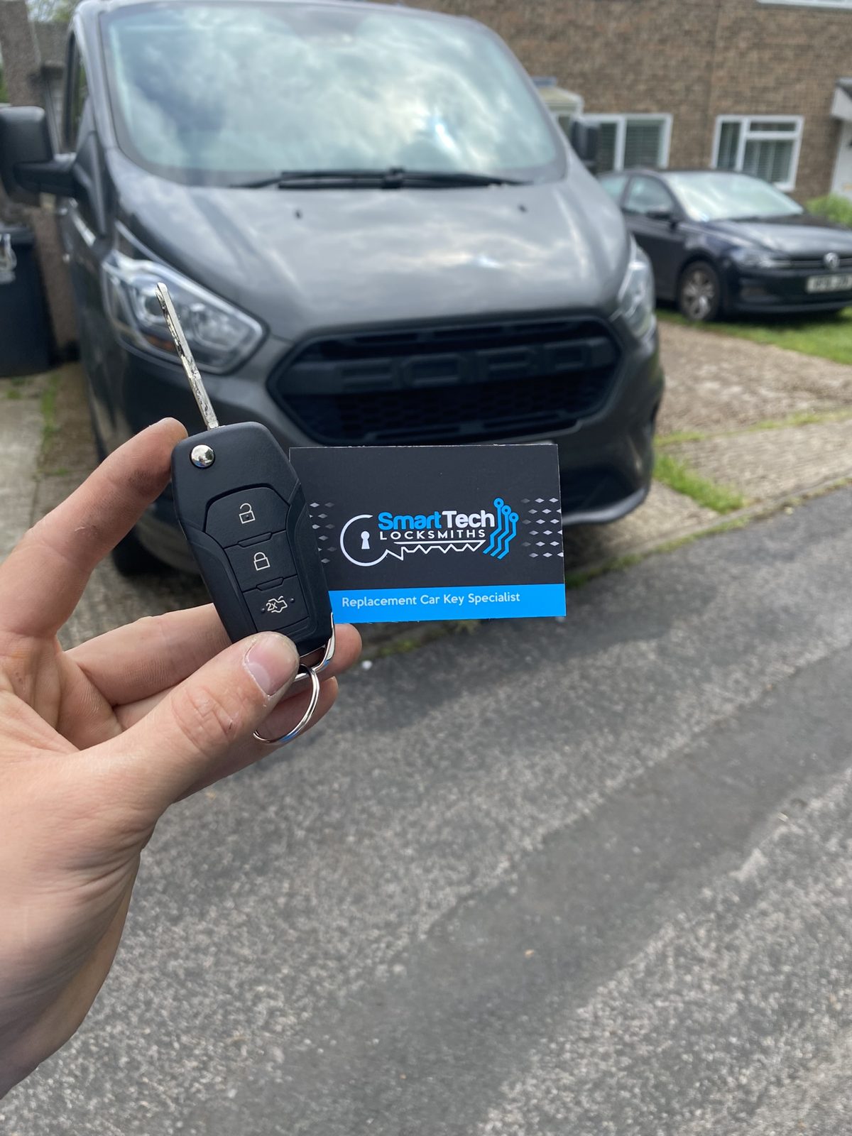 Ford Transit Custom van flip key in Hampshire by SmartTech Auto Locksmiths, key and business card held in front of the vehicle