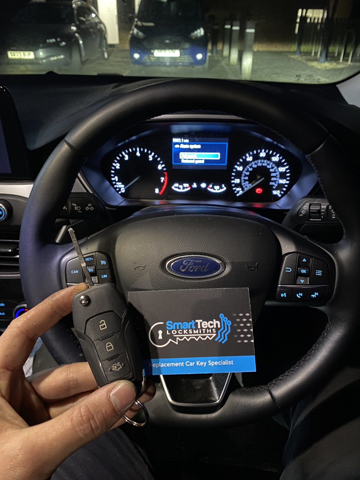 Ford Transit flip key programmed in Hampshire by SmartTech Auto Locksmiths, key and business card held in front of the vehicle