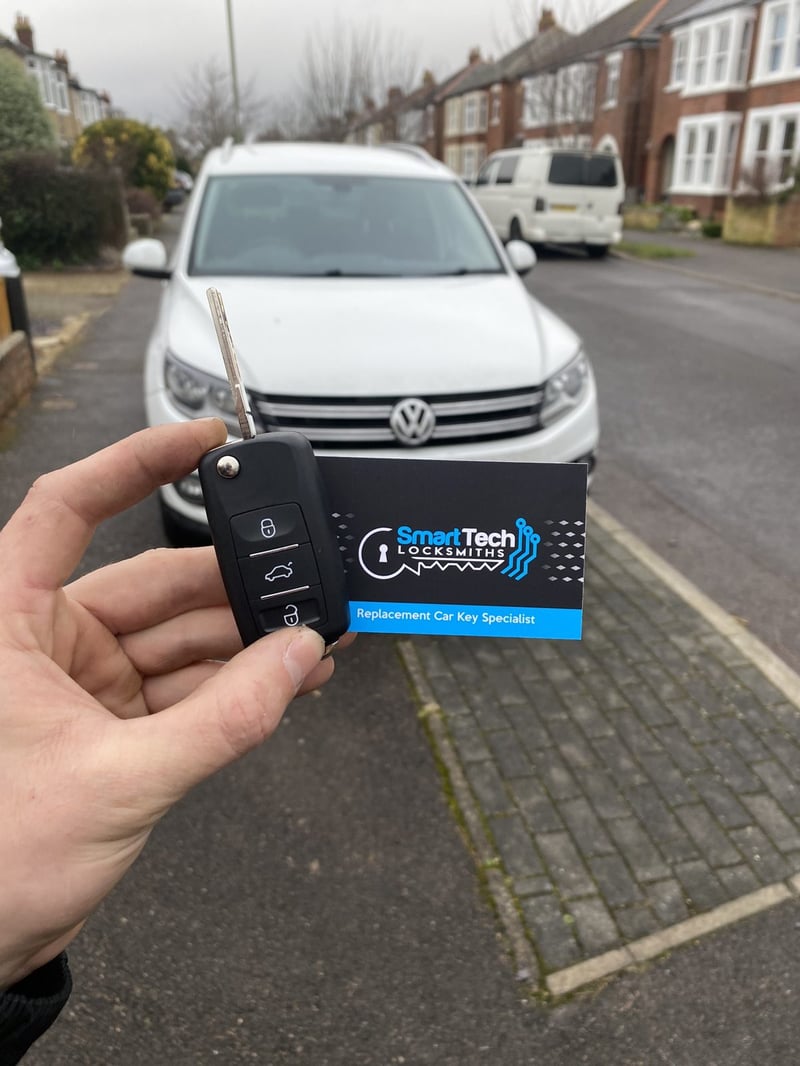 Volkswagen Caddy flip key cut and coded in Totton by SmartTech Auto Locksmiths, key and business card held in front of the vehicle