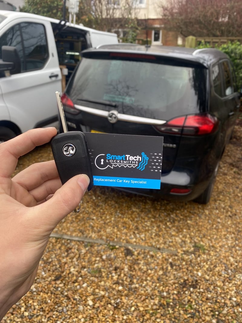 Vauxhall Zafira replacement key in Netley & Hamble by SmartTech Auto Locksmiths, key and business card held in front of the vehicle