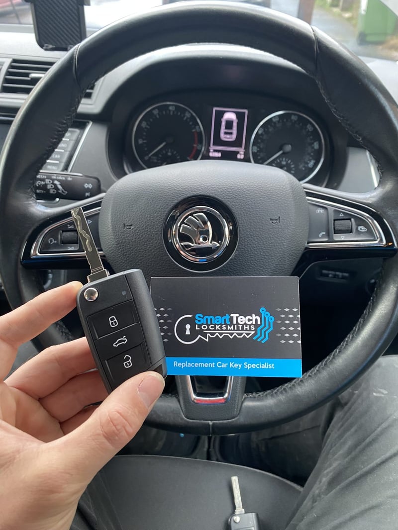 Skoda flip key cut and coded in Hampshire by SmartTech Auto Locksmiths, key and business card held in front of the vehicle