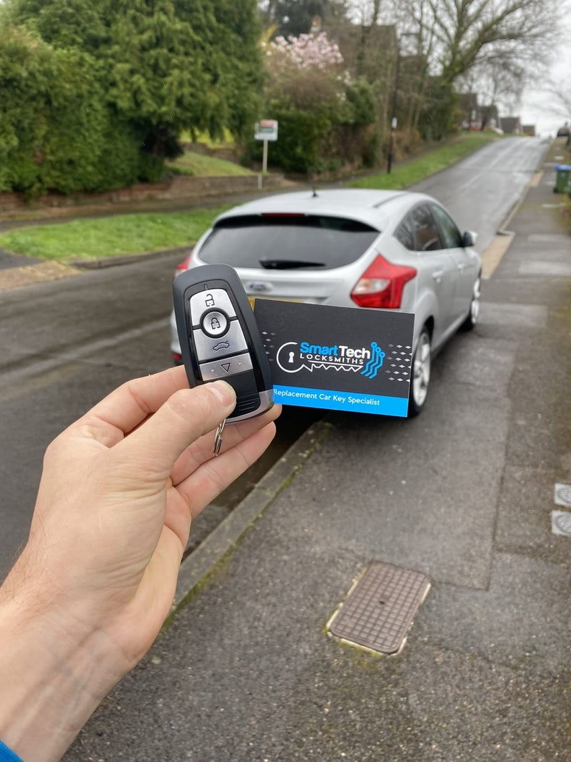 Ford Focus smart key programmed in Hampshire by SmartTech Auto Locksmiths, key and business card held in front of the vehicle