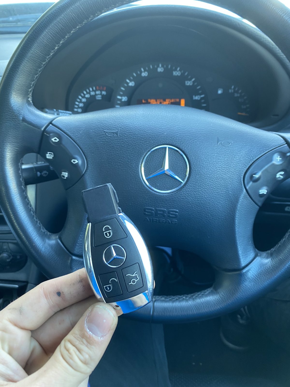 Mercedes-Benz replacement key in Hampshire by SmartTech Auto Locksmiths, key and business card held in front of the vehicle