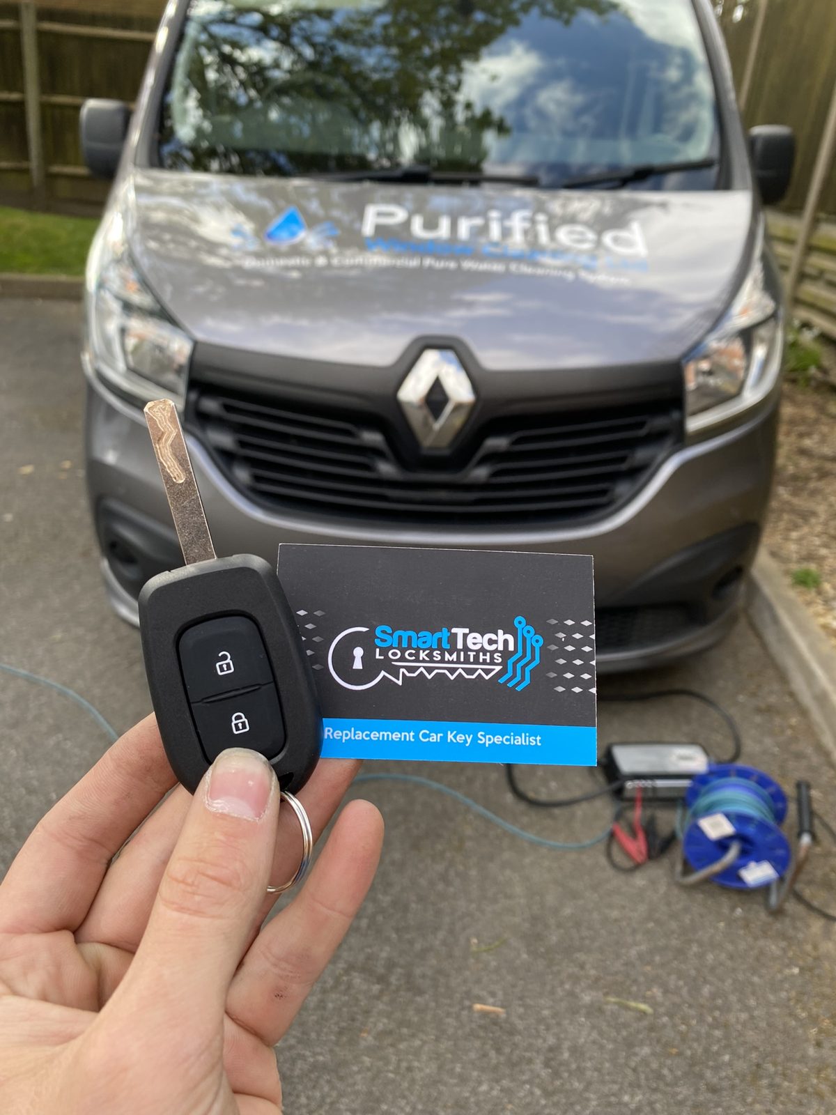 Renault Trafic van key cut and coded in Hampshire by SmartTech Auto Locksmiths, key and business card held in front of the vehicle