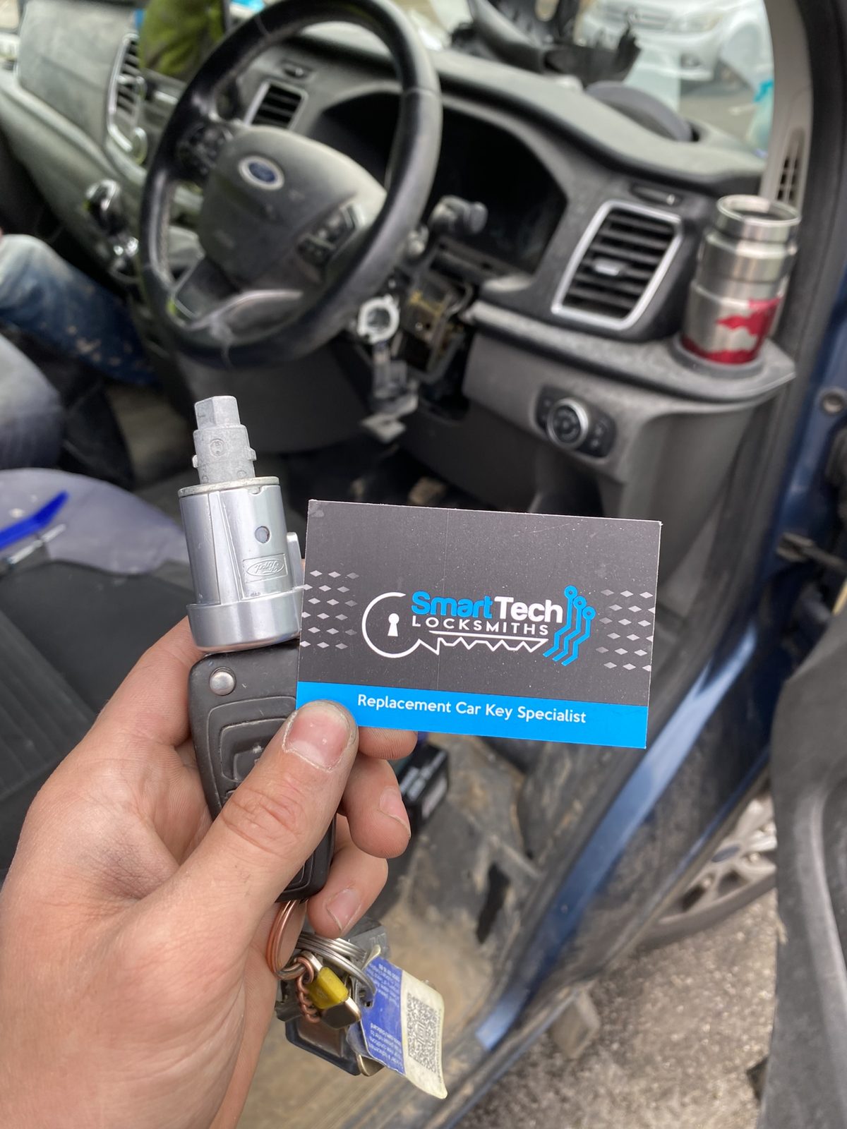 Ford Transit ignition lock replaced in Hampshire by SmartTech Auto Locksmiths, key and business card held in front of the vehicle
