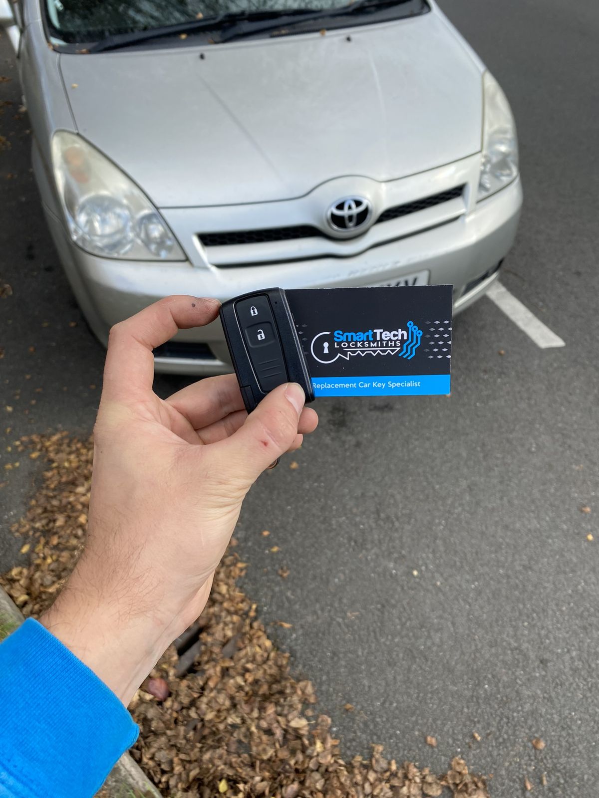 Toyota Corolla Verso spare remote key in Southampton by SmartTech Auto Locksmiths, key and business card held in front of the vehicle