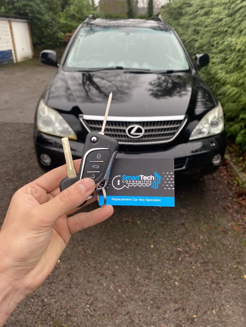 Lexus RX flip key cut and coded in Winchester by SmartTech Auto Locksmiths, key and business card held in front of the vehicle