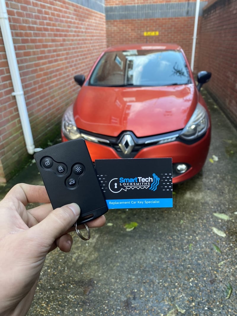 Renault Clio key card programmed in Fareham by SmartTech Auto Locksmiths, key and business card held in front of the vehicle