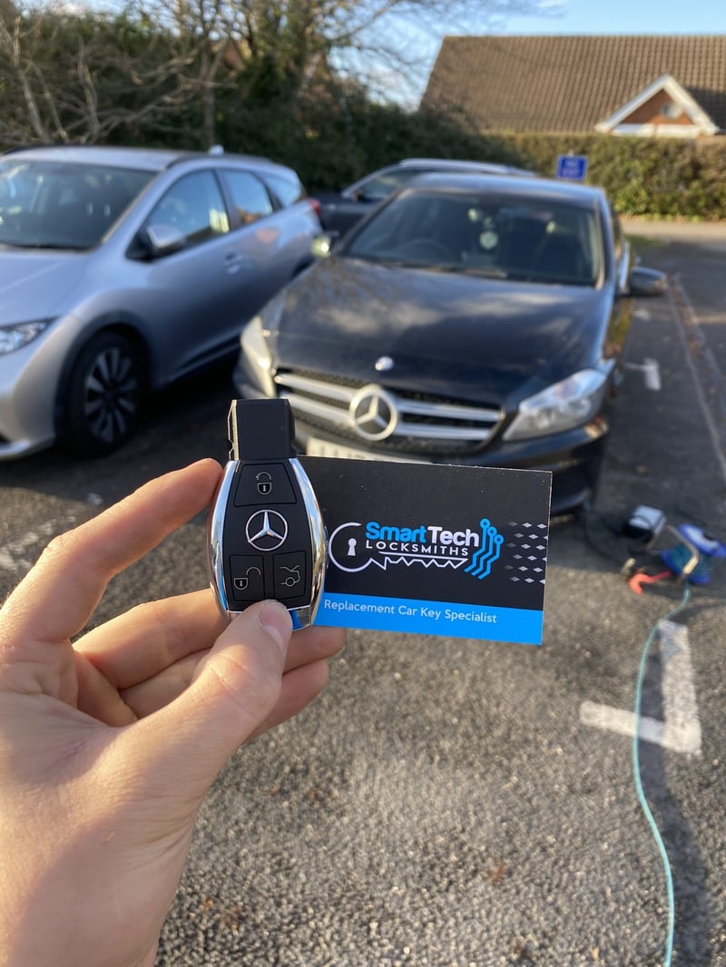 Mercedes-Benz A-Class replacement key in Lymington by SmartTech Auto Locksmiths, key and business card held in front of the vehicle