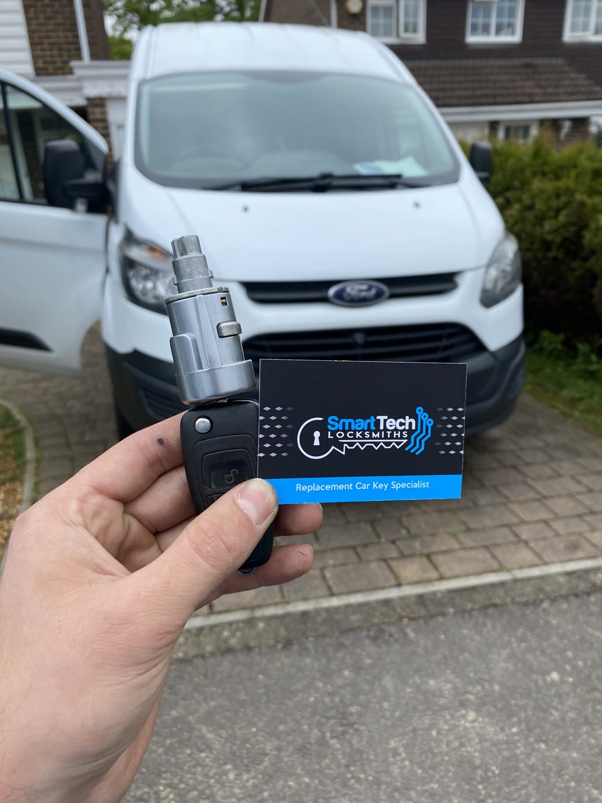 Ford Transit Custom ignition lock and key in Hampshire by SmartTech Auto Locksmiths, key and business card held in front of the vehicle