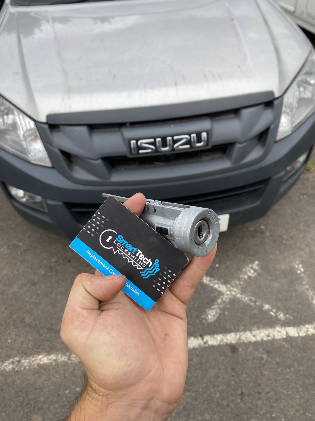 Isuzu D-Max ignition barrel replaced in Bitterne by SmartTech Auto Locksmiths, key and business card held in front of the vehicle